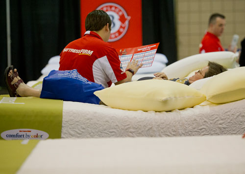 Denise Rice (right) talks with Tyler Molleson as she lays on a mattress during the 35th Annual Spring Atlanta Home Show at the Cobb Galleria Center in Atlanta on Saturday, March 23, 2013. 