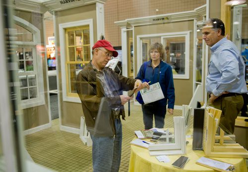 John Seymour (left) looks over a brochure as he and his wife Jill talk to Tom Zakucia during the 35th Annual Spring Atlanta Home Show at the Cobb Galleria Center in Atlanta on Saturday, March 23, 2013. 