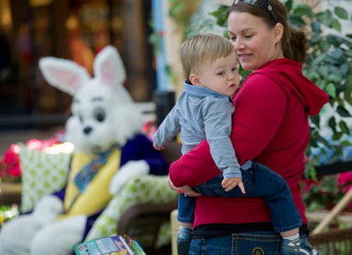 Nicole Harlin (right) holds her son Chase as they wait in line to visit with the Easter Bunny at North Point Mall in Alpharetta on Thursday, March 21, 2013. 
