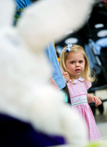 Raegan Chapman sizes up the Easter Bunny from behind her mother's leg at North Point Mall in Alpharetta on Thursday, March 21, 2013. 
