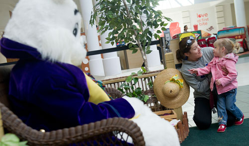 Anna Fishel (right) whispers to her mother Crystal as she sizes up the Easter Bunny at North Point Mall in Alpharetta on Thursday, March 21, 2013. 