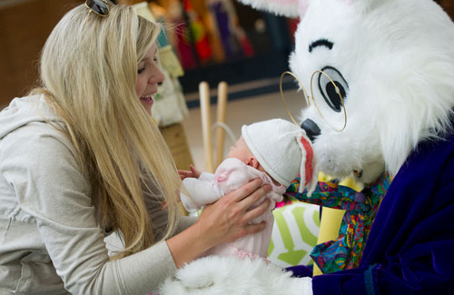 Juliette Johnson (left) places her five week old daughter Caroline into the Easter Bunny's arms at North Point Mall in Alpharetta on Thursday, March 21, 2013. 