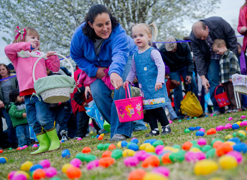 Erin Szymanowski (left) places an egg in her basket as Jill White points out an egg for her daughter Leila during the Easter Egg Hunt at Nash Farm Battlefield in Hampton on Friday, March 22, 2013.