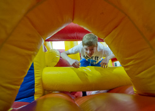 Cameron Shaw runs through an inflatable obstacle course during the fifth annual Easter Egg Hunt at Hebron Christian Church in Winder on Sunday, March 24, 2013.