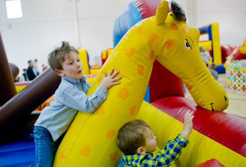 Traveler Whaley (left) and Grant Loftin bounce off of an inflatable giraffe during the fifth annual Easter Egg Hunt at Hebron Christian Church in Winder on Sunday, March 24, 2013.