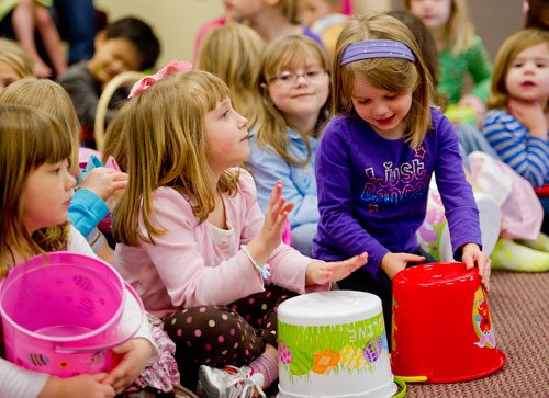Caroline Peccia (left) and Lily Goins use their Easter baskets as drums before the start of the fifth annual Easter Egg Hunt at Hebron Christian Church in Winder on Sunday, March 24, 2013.