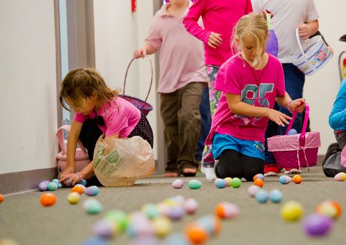 Anna Eady (left) and Morgan Eddings place eggs in their baskets during the fifth annual Easter Egg Hunt at Hebron Christian Church in Winder on Sunday, March 24, 2013. 