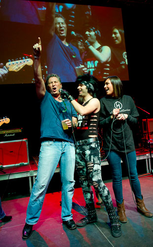 Floyd Shiffman (left) and Hayley Koch (right) battle it out during a sing off with the help of the lead singer of The Breakfast Club, Josh Scholl, as they perform on stage during the fifth annual ShamRockin for a Cure at the Verizon Wireless Amphitheatre in Alpharetta on Saturday, March 9, 2013. 