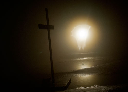 A spotlight illuminates a wooden cross as it stands shrouded in clouds on top of Stone Mountain before the start of the 69th annual Easter Sunrise Service at Stone Mountain Park on Sunday, March 31, 2013. 