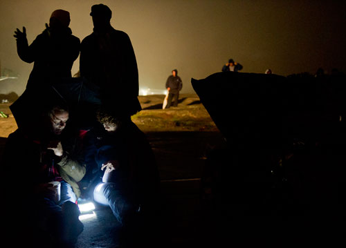 Vick Leonard (bottom left) and his wife Dawn use a flashlight to look at the program for the 69th annual Easter Sunrise Service on top of Stone Mountain at Stone Mountain Park on Sunday, March 31, 2013.