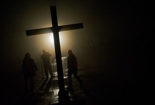 Shelby Miles (left), Danny Williford and Kristie Miles walk towards the wooden cross on top of Stone Mountain before dawn breaks for the 69th annual Easter Sunrise Service at Stone Mountain Park on Sunday, March 31, 2013.