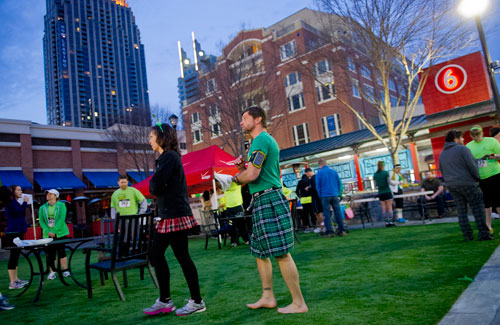 Christie Pinaud (left) and her husband Tom walk through Central Park at Atlantic Station before the start of the Junior League of Atlanta's 9th annual ShamRock 'N Roll Road Race on Sunday, March 10, 2013. 