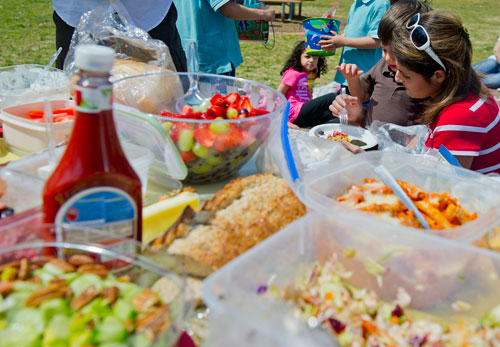 Nona Ghazban (right) helps her son Daniel fix a plate of food as friends and family picnic at Jones Bridge Park in Peachtree Corners on Saturday, March 30, 2013.