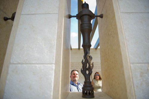 Andy Gelernter (left) lights one of the six torches at the Besser Holocaust Memorial Garden at the Marcus Jewish Community Center of Atlanta in Dunwoody as his sister in law Michele Gelernter waits to light another torch during a Yom HaShoah commemoration ceremony on Sunday, April 7, 2013.