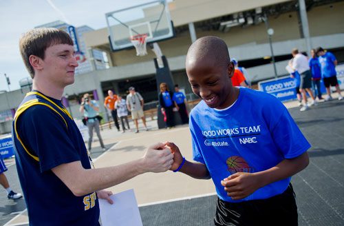 Jake Greene (left), a senior guard from LSU-Shreveport, hands out a high five to Christian Sims as he works as a coach during the Allstate NABC Good Works Team Basketball Clinic at Atlantic Station in Atlanta on Sunday, April 7, 2013. 