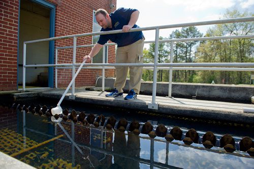 Josh Brazeal, a water quality specialist at the water plant on the southwest corner of Waller Park in Roswell, takes a sample to test for settled water turbidity on Wednesday, April 10, 2013.