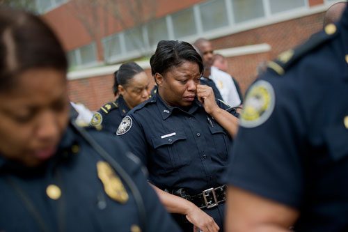 Atlanta Police Officer Sharon Leonard (center) wipes tears from her eyes during the unveiling of three officers' names on the Georgia Law Enforcement Memorial Wall outside of the Public Safety Headquarters in Atlanta on Thursday, April 11, 2013.
