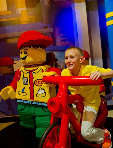 Lance Witt sits on a bicycle next to a LEGO workman at the LEGOLAND Discovery Center at Phipps Plaza in Buckhead on Monday, April 8, 2013.