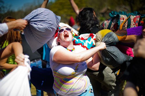 Christine Penguino (center) swings her penguin pillow wildly during the pillow fight at Freedom Park in Little Five Points on Saturday, April 6, 2013. 