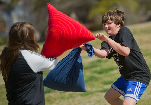 Coleman Marker (right) practices his swing with Emmie Corder before the start of the pillow fight at Freedom Park in Little Five Points on Saturday, April 6, 2013.