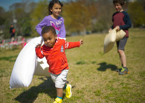Kalil Tennant (left) runs from Ahva Minina and Sagor Levy before the start of the pillow fight at Freedom Park in Little Five Points on Saturday, April 6, 2013. 