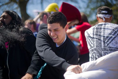 Sebastian Reina (center) swings his pillow wildly during the pillow fight at Freedom Park in Little Five Points on Saturday, April 6, 2013. 