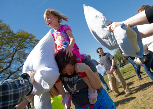 Leela Bagby (top) spins on her mother Cheryl's shoulders as she is attacked with pillows during the pillow fight at Freedom Park in Little Five Points on Saturday, April 6, 2013. 