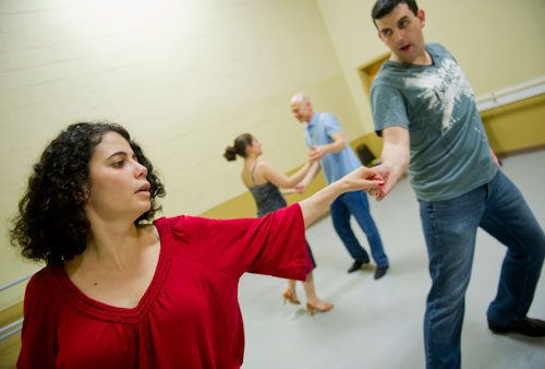 Marise Teixeira (left) and Joel DeSalvo stretch out while Marie Collantes and Jon Cohen do the same behind them as they practice a new dance step during a Dance 4 Fun swing class in Lawrenceville on Monday, April 15, 2013. 
