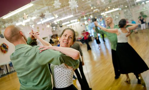 Kitty Canupp (center) is led around the dance floor by instructor Rainier Rics during a private lesson at Atlanta Ballroom Dance Centre in Sandy Springs on Wednesday, April 17, 2013.