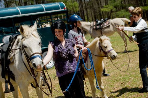 Dawn Gray (left) holds her horse by its halter as her daughter Sydney sits atop her pony while her mother-in-law Linda waits for her horse before leaving on an eight mile trail ride in Covington on Tuesday, April 2, 2013.