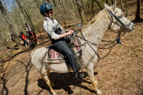 Linda Gray sits on her horse as Dennis Horion helps her daughter-in-law Dawn and her twin sister Carol Witts mount up to continue their trail ride along the Alcovy River in Covington on Tuesday, April 2, 2013.
