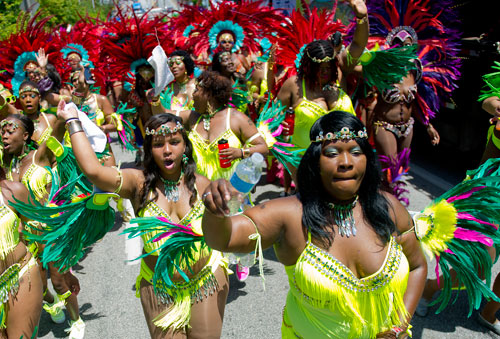 Kia Williams (right) and Ajewel Granville dance their way up Martin Luther King Dr. during the parade for the 25th annual Atlanta Caribbean Carnival at Morris Brown Herndon Stadium in Atlanta on Saturday, May 25, 2013. 