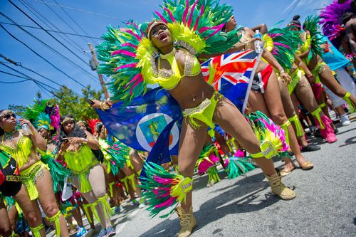 Crystal Davis (center) dances her way up Martin Luther King Dr. during the parade for the 25th annual Atlanta Caribbean Carnival at Morris Brown Herndon Stadium in Atlanta on Saturday, May 25, 2013. 