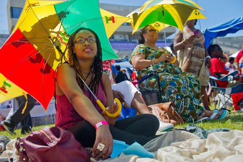Amiyra Fitz (left) and her mother Michelle shade themselves from the sun under flag umbrellas during the 25th annual Atlanta Caribbean Carnival at Morris Brown Herndon Stadium in Atlanta on Saturday, May 25, 2013. 