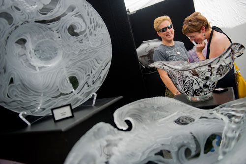 Leah Rushing (left) and Jody Miles look at glass sculptures designed by Sam Markham-Brewster during the Decatur Arts festival in downtown Decatur on Saturday, May 25, 2013.
