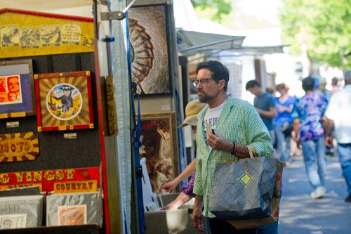 Max Sanchez carries his bags as he peruses the booths at the Decatur Arts festival in downtown Decatur on Saturday, May 25, 2013. 