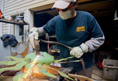 Marlene Hopkins uses a plasma torch to cut a face into one of the steel sculptures she and her husband Jimmy create at their home in Woodstock on Monday, April 29, 2013. 