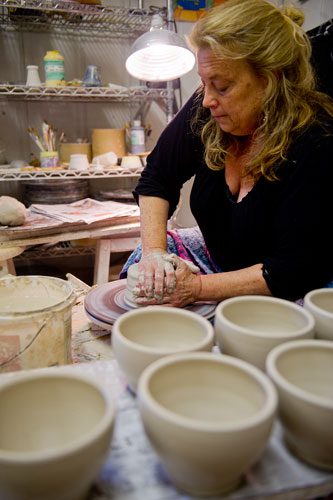Polly Sherrill uses a wheel to throw clay into a bowl as she prepares for her next art festival at her studio in Atlanta on Tuesday, April 30, 2013. 