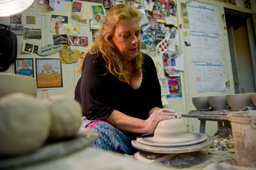 Polly Sherrill uses a wheel to throw clay into a bowl as she prepares for her next art festival at her studio in Atlanta on Tuesday, April 30, 2013. 