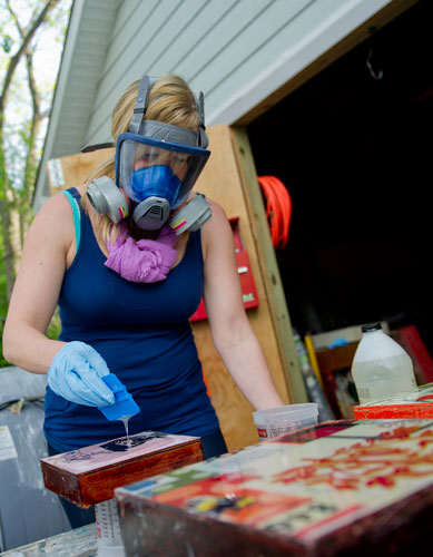 Jennie Juechter applies a layer of epoxy to a finished mixed media piece that she and her partner Alex Wright created at their home in East Point on Tuesday, April 30, 2013.