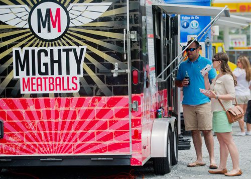 Jessica Welburn (right) and Matt Hettler order food from Mighty Meatballs at the Atlanta Food Truck Park & Market off of Howell Mill Road on Saturday, May 11, 2013. 
