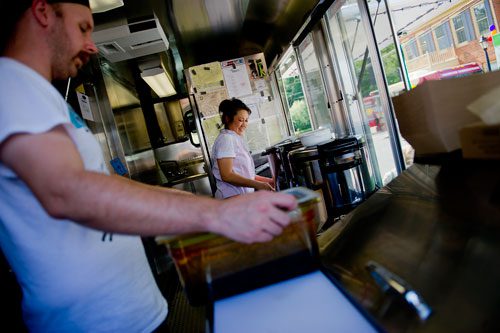 Nomie Truong (right) and Drew Moody prepare food orders inside the Viet-Nomie's food truck in Roswell on Thursday, May 16, 2013. 