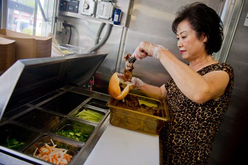 Thuy Tran prepares food orders inside the Viet-Nomie's food truck in Roswell on Thursday, May 16, 2013.