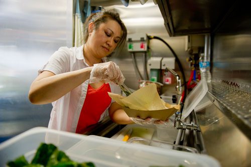 Nomie Truong prepares food orders inside the Viet-Nomie's food truck in Roswell on Thursday, May 16, 2013. 