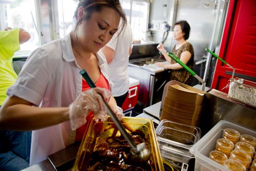Nomie Truong (left) and her mother Thuy Tran prepare food orders inside the Viet-Nomie's food truck in Roswell on Thursday, May 16, 2013. 