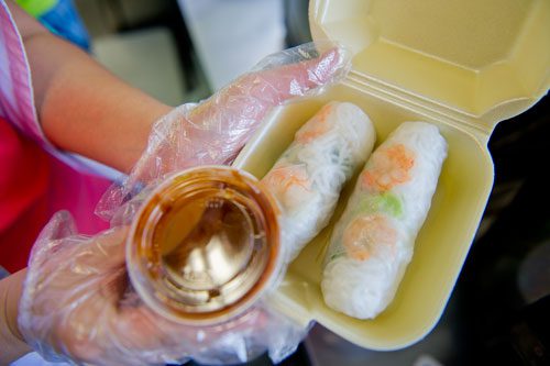 Nomie Truong holds an order of summer rolls before handing it to a customer on Thursday, May 16, 2013.