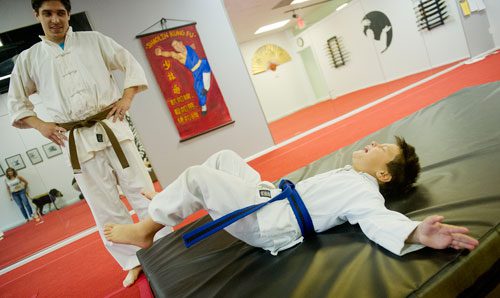 Andres Eskildsen-Lee (right) is taught to fall without hurting himself by David Drake during Kung Fu Camp at Highland Martial Arts in the Virginia Highlands neighborhood of Atlanta on Wednesday, June 12, 2013.