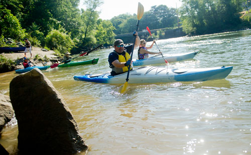 Lake Summerhill (center) and Aliina Rousu paddle their kayaks as they take off from the starting line during the Back to the Chattahoochee River Race & Festival in Roswell on Saturday, June 15, 2013. 