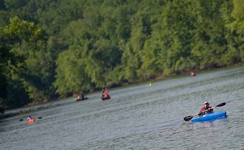 Kelly Harbac (bottom right) paddles her kayak as she nears Don White Memorial Park during the Back to the Chattahoochee River Race & Festival in Roswell on Saturday, June 15, 2013. 