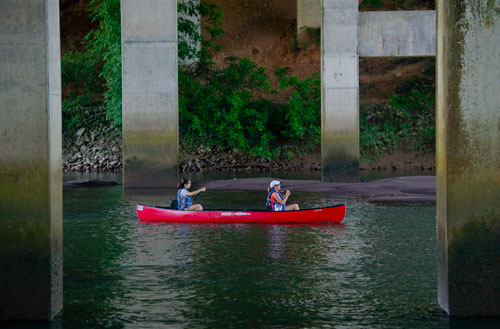 Betsy Gentry and Sophie Harkins paddle their canoe under the bridge at Don White Memorial Park in Roswell during the Back to the Chattahoochee River Race & Festival on Saturday, June 15, 2013.